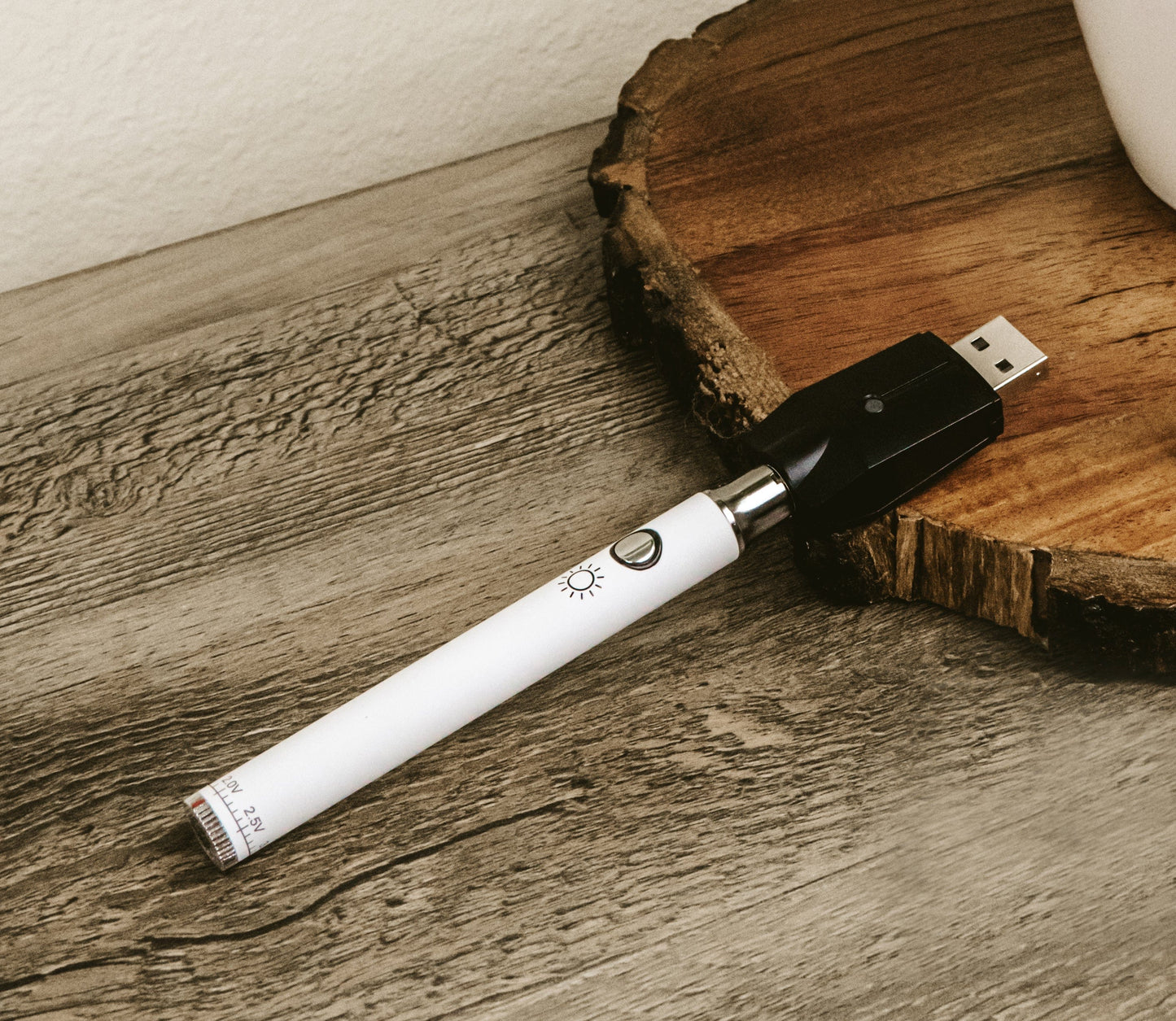 Close-up of the Day 510 Vape Battery against a rustic wooden surface, showing its sleek, cylindrical form and charging port.