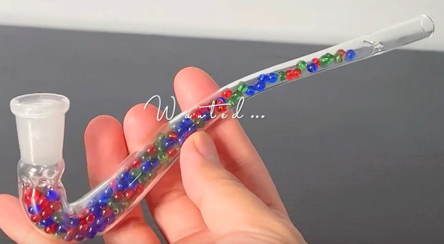 A close-up, angled view of the Beaded J Hook Glass Stem, showing colorful beads along the curved glass tube held in a hand.
