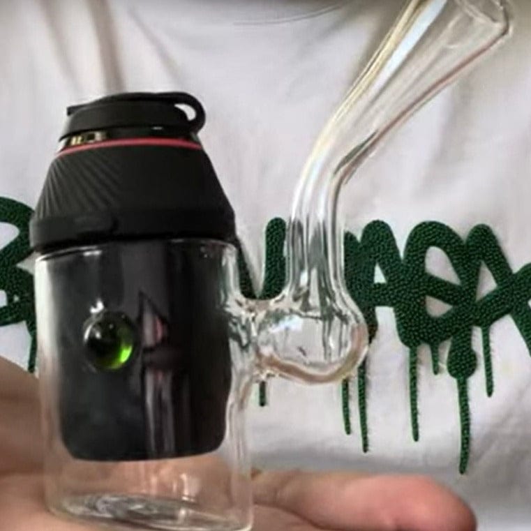 A close-up, angled view of the Sherlock Dry Pipe for Puffco Proxy, held in a hand against a white graphic t-shirt.