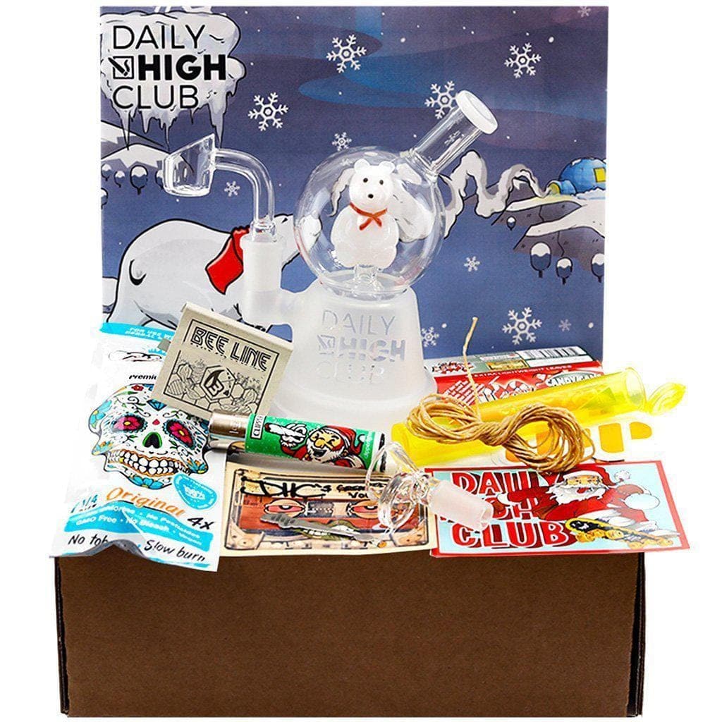 A top-down view of the “Polar Bear Holiday” Smoking Box, showcasing colorful packaging around a clear glass pipe and various accessories.