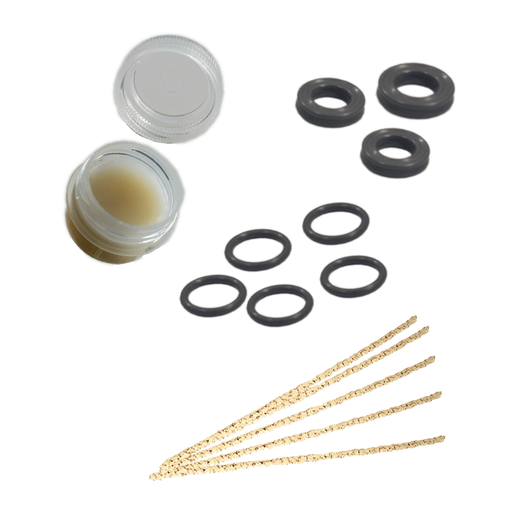 A top-down view of several black rubber o-rings alongside the DynaKit: Maintenance container, all against a plain white background.