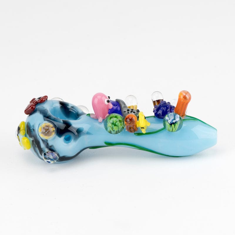 A side view of the Great Barrier Reef Small Spoon Pipe, featuring colorful coral-like glass accents along its curved form.
