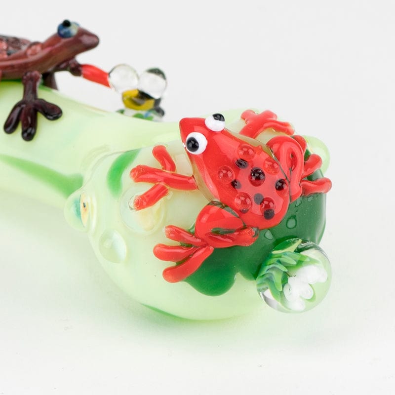 A close-up of the Ribbit Small Spoon Pipe, featuring a green and clear glass bowl with a sculpted frog detail.