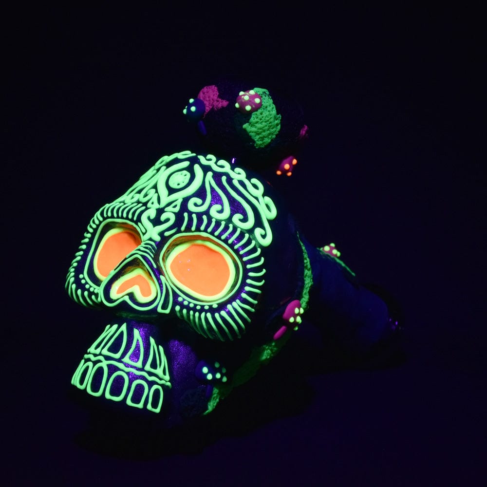 A vibrant close-up of the Pulsar Voodoo Skull Bubbler Pipe, showcasing a detailed skull design with colorful accents against a dark backdrop.