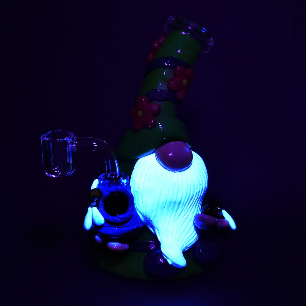 Front view of the 7-inch Flower Gnome Glass & Enamel Dab Rig, illuminated with a vibrant blue glow against a dark background.