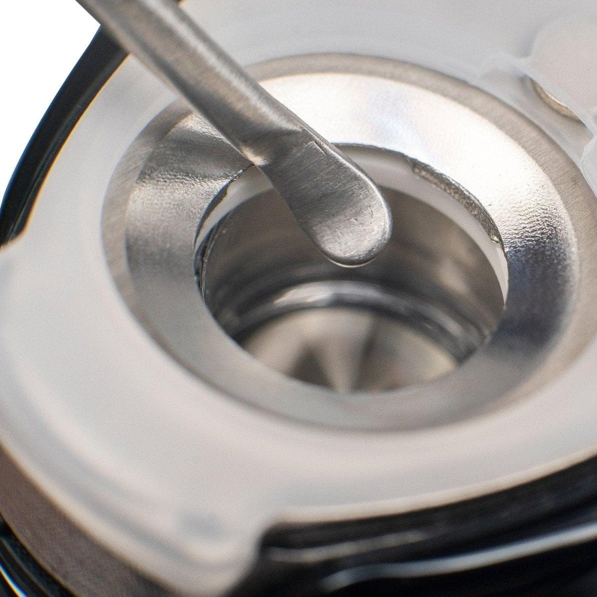 Close-up view of the Loading Tool, showing a metallic end against a dark, reflective background.