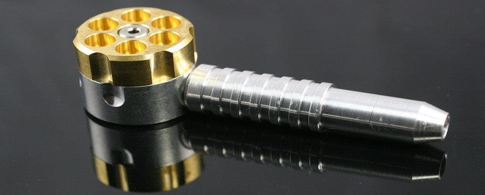 A studio shot captures The Original Six Shooter Pipe with a metallic, multi-chambered mouthpiece against a dark, reflective surface.
