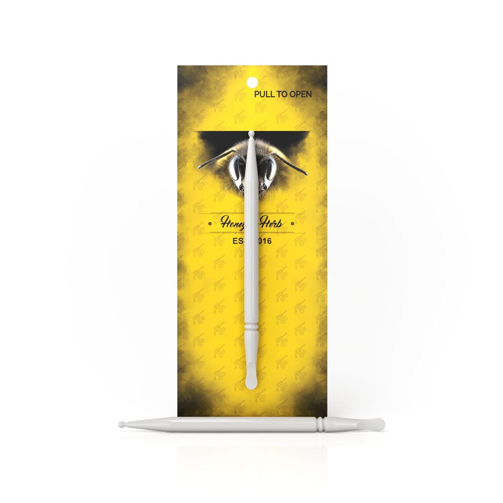 Front view of the Organic Ceramic Dab Tool with a white ceramic tip against a patterned background, shown in its packaging.