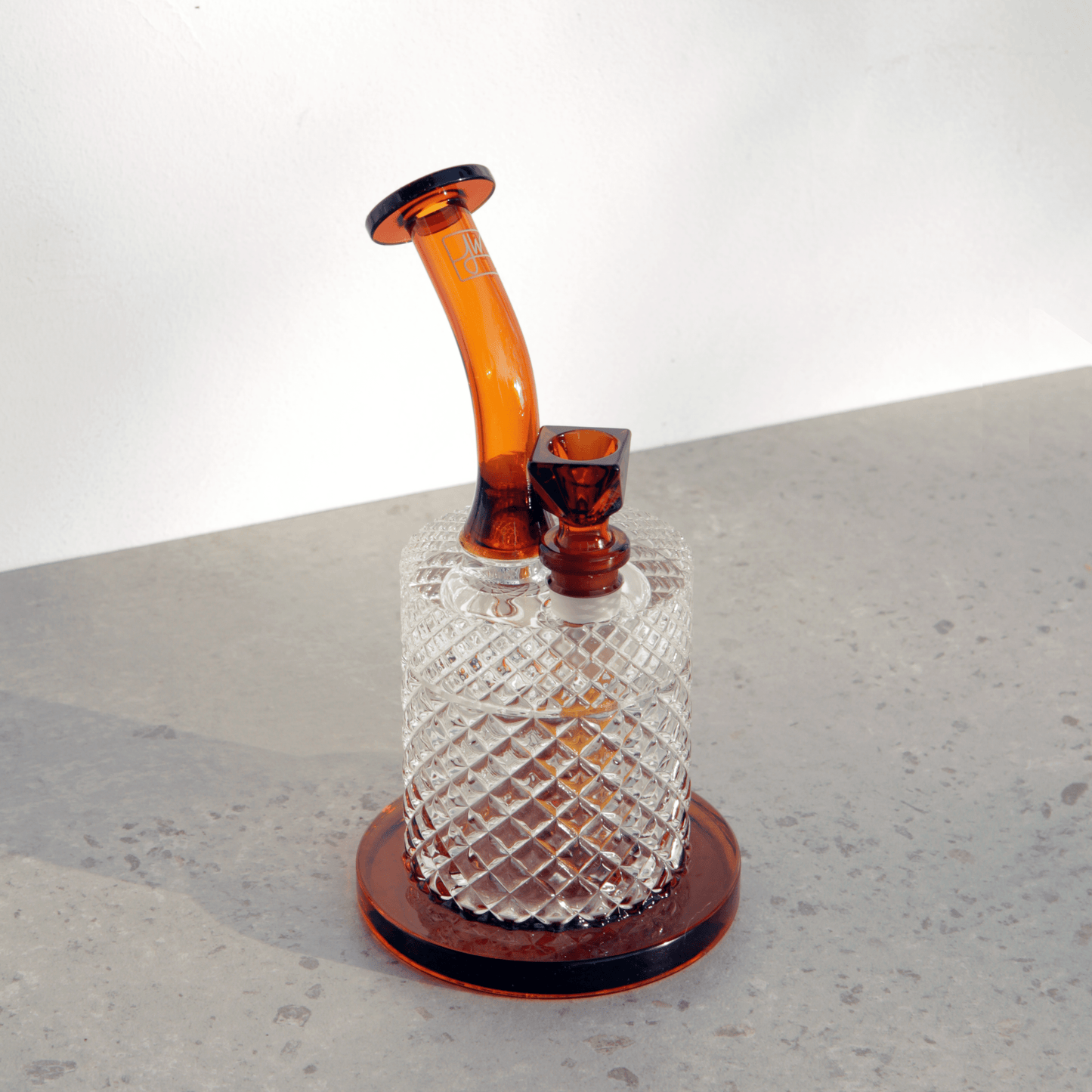 A front view of the Jane West Twenties Collection water pipe, showcasing its textured glass base and amber-toned mouthpiece.