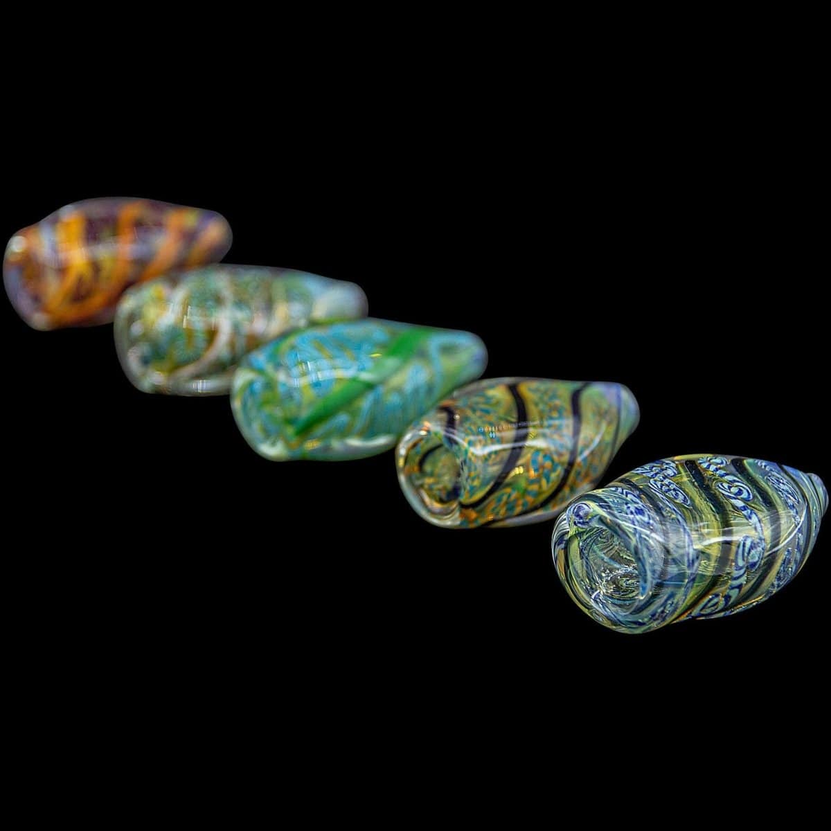 A slightly angled view of the “Skipping Stone” Inside-Out Chillum, showcasing its transparent, colorful glass construction.
