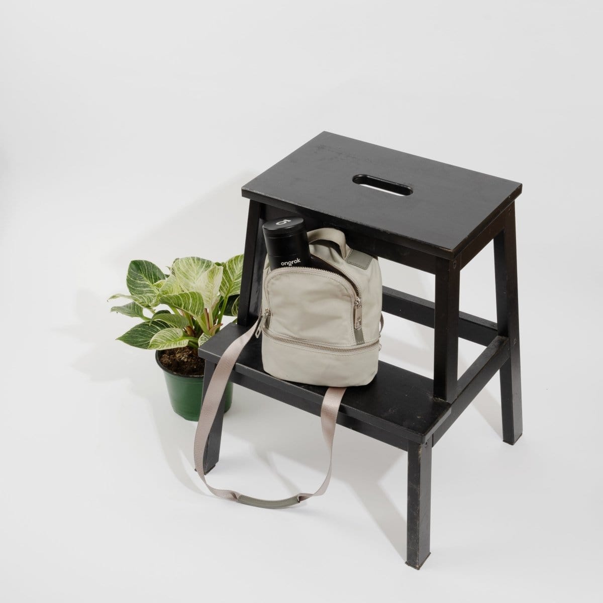 A slightly angled, top-down view of the 5 Piece Storage Grinder on a dark wood surface, showing its compact size.