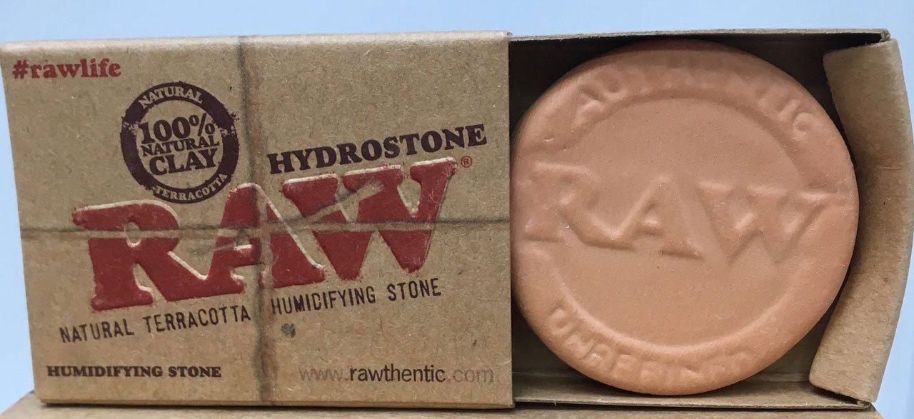 Front view of the Raw Hydrostone, a stone-colored, cylindrical object with branding visible on its surface.