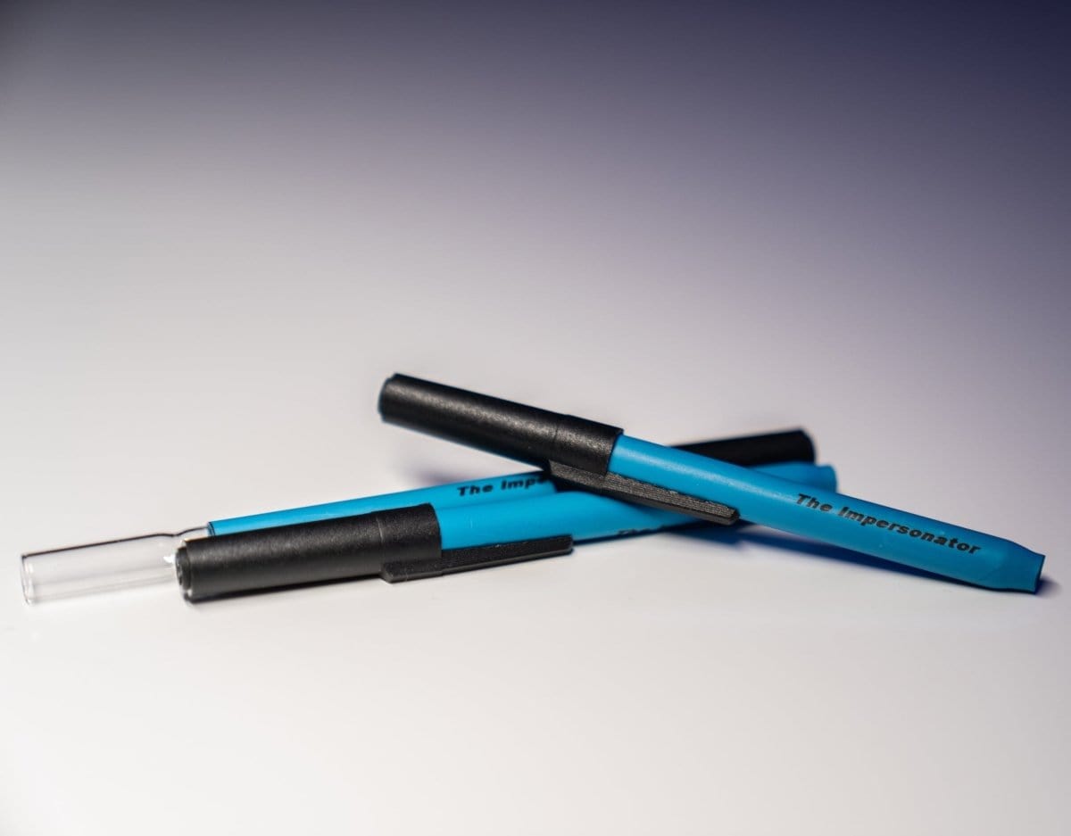 A high-angle view of The Impersonator 3-Pack, showcasing three clear glass pipes against a dark background.