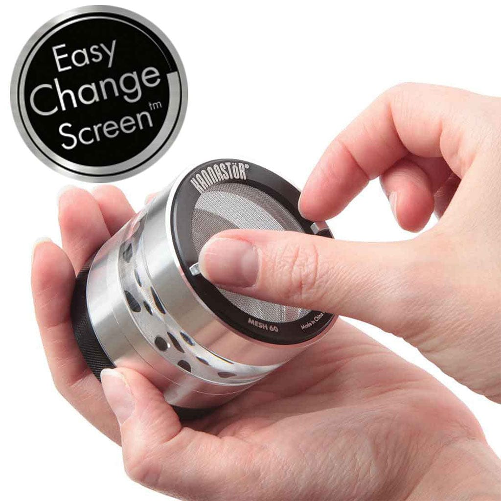 Close-up of hands holding a silver Ryot 4Pc Jar Body Grinders, showing a fingertip lifting the mesh screen from the top under bright, even lighting.