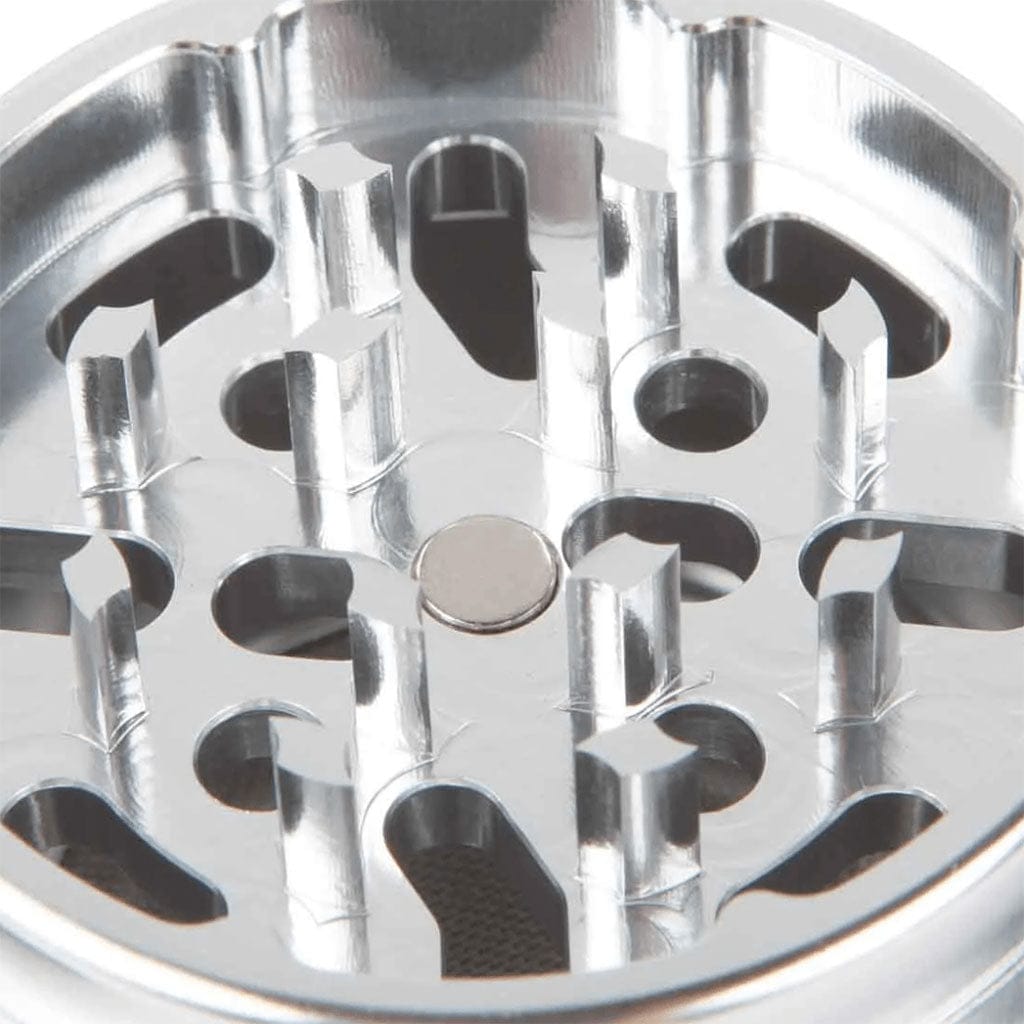 Close-up top view of the shiny metal teeth and holes on the Ryot 4Pc Jar Body Grinders, lit to show reflective surfaces and inner mesh.