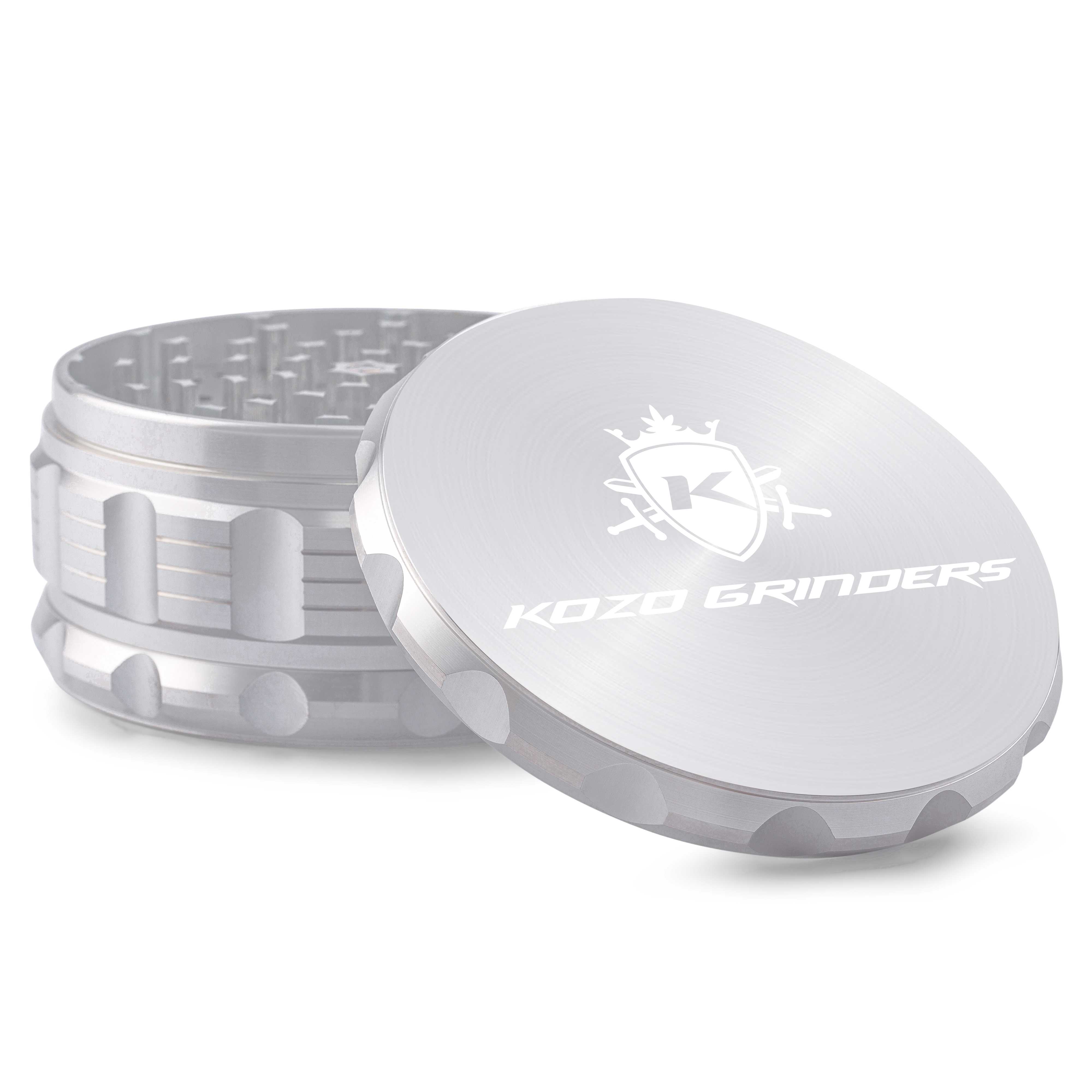 Close-up three-quarter view of the metallic Kozo Grinder 4" showing its textured side grip, tooth-filled chamber, and engraved lid.