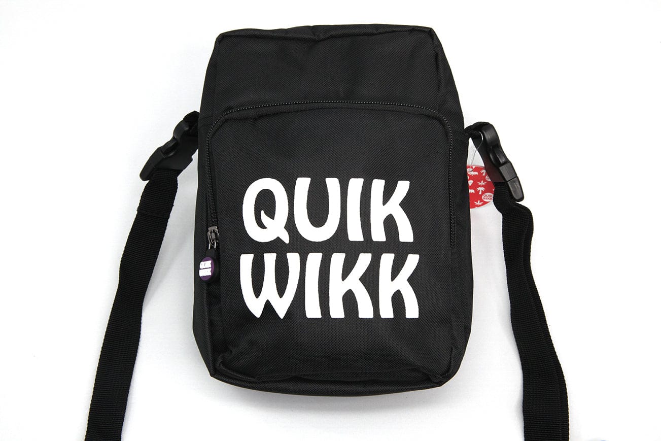 Top-down view of a black Quik Wikk Shoulder Cross Body Bag with bold white "QUIK WIKK" print on the front pocket and straps spread out.