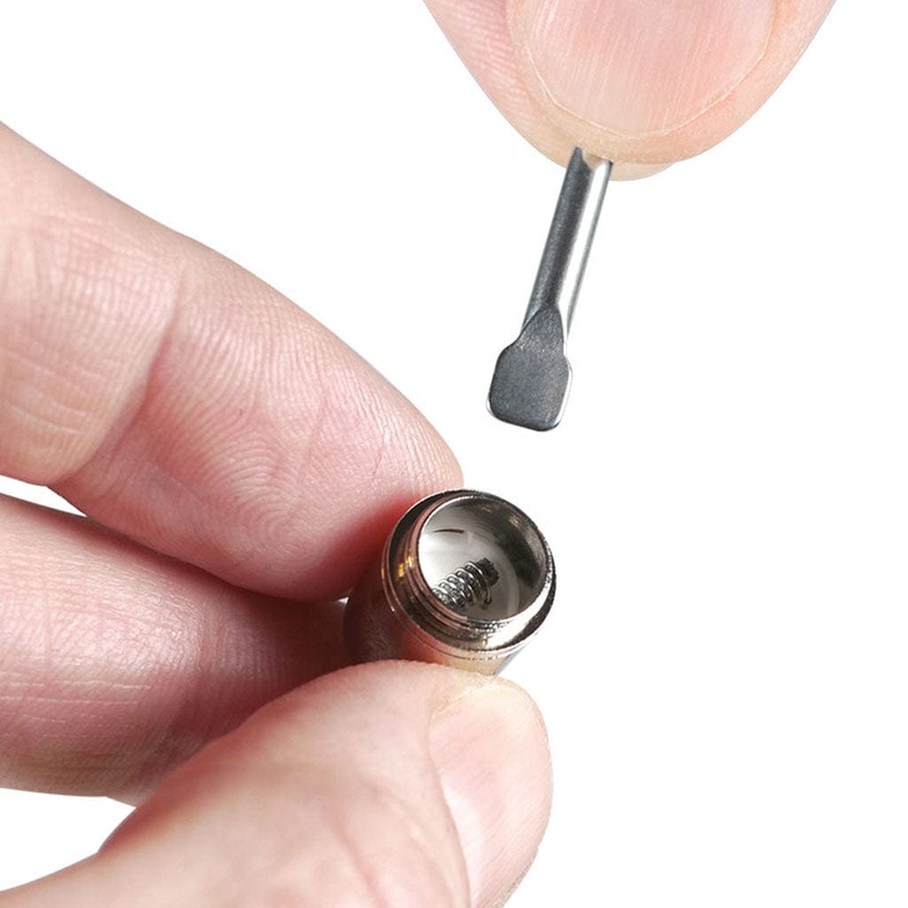 Close-up of a hand holding the Ryotâ® 3 Pack Of Extra Coils For 710 Wax Tank - New coil with a small metal pick poised above it on a white background