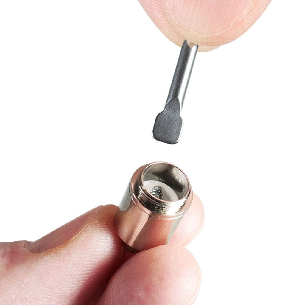 Close-up of a fingertip holding a single Ryotâ® 3 Pack Of Extra Coils For 710 Wax Tank - New metal coil while a small flat metal tool is poised above it against a white background