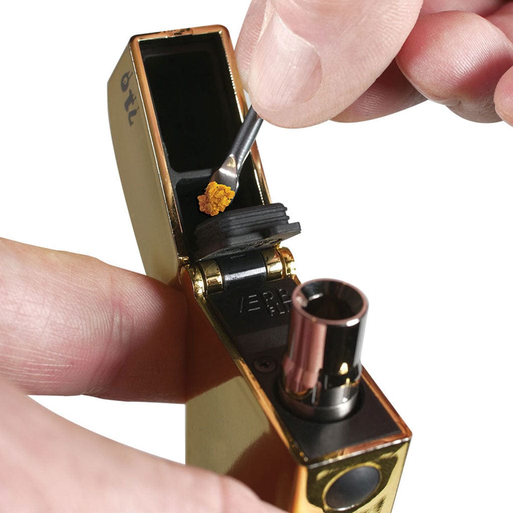 Close-up of a hand loading wax into the open Ryotâ® 3 Pack Of Extra Coils For 710 Wax Tank - New, shown at a slight top-front angle against a white background.