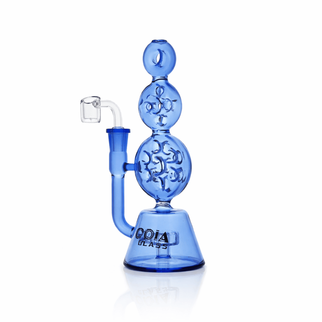 Studio-lit side view of the Croia Glass 8" Triple Stack Swiss Perc Recycler Dab Rig in translucent blue showing three stacked spherical chambers and a clear quartz banger.