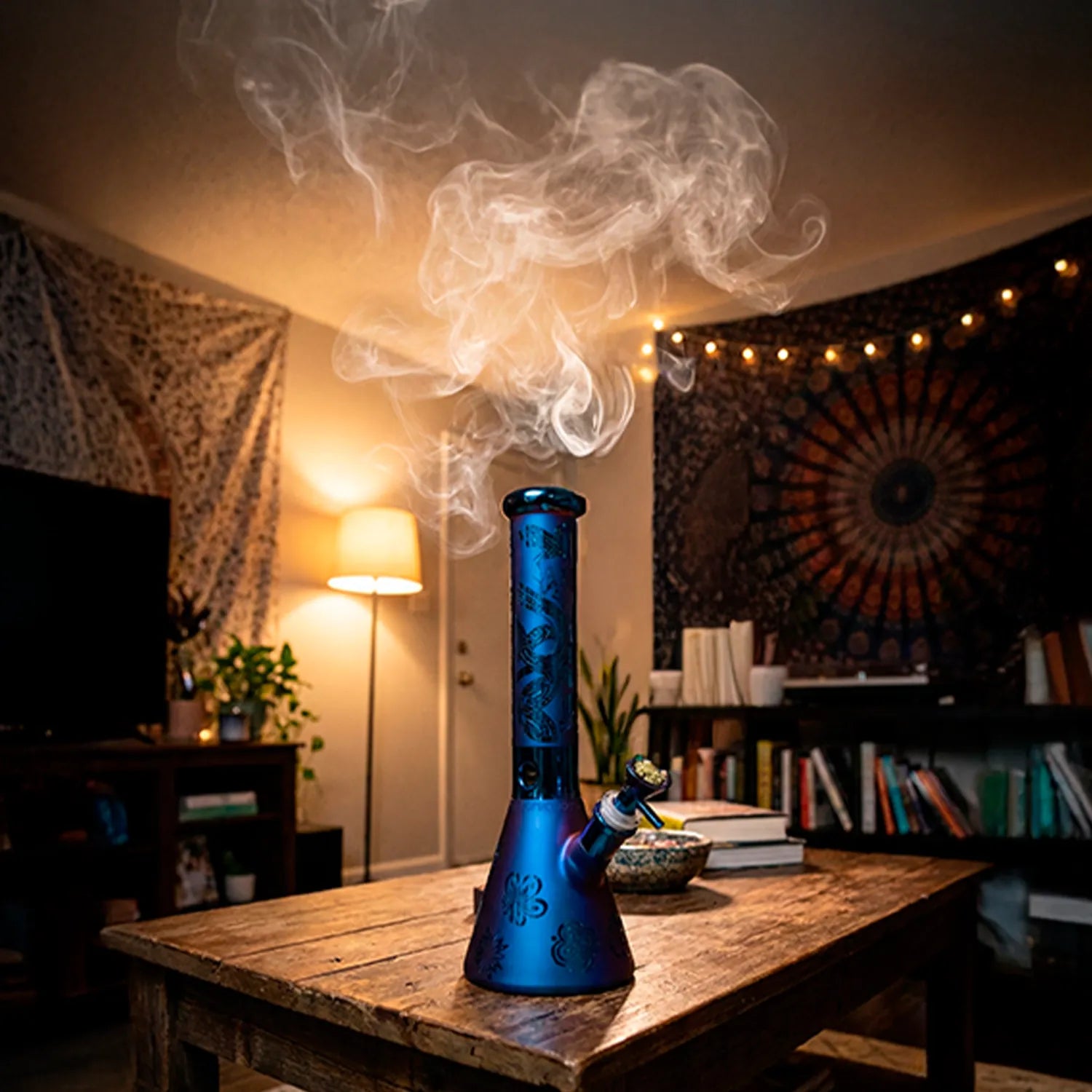 Center front view of the DHC Electro Plated Beaker Bong - 10 in. in blue-purple finish on a wooden coffee table with smoke rising and warm room lighting.