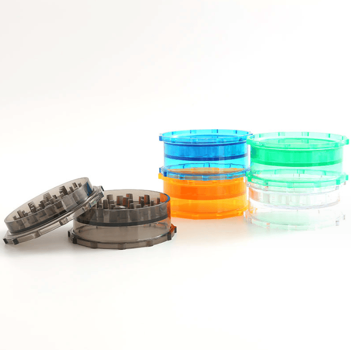 Three-quarter front view of stacked colorful 3" Large Plastic Grip Edge Grinder pieces with one smoky set opened in the foreground.
