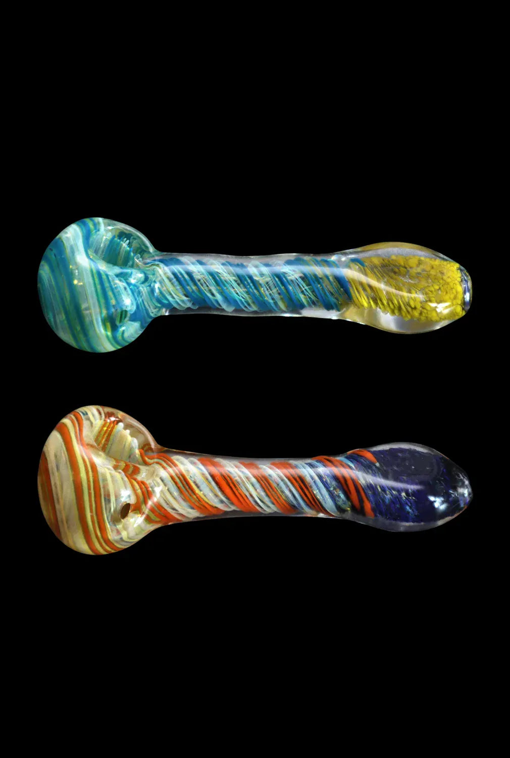 Top-down view of two twisted glass DHC Color Twisting Spoon Pipe - 3 in. hand pipes, one blue-green with a yellow tip and one red-orange with a dark purple tip, set against a black background