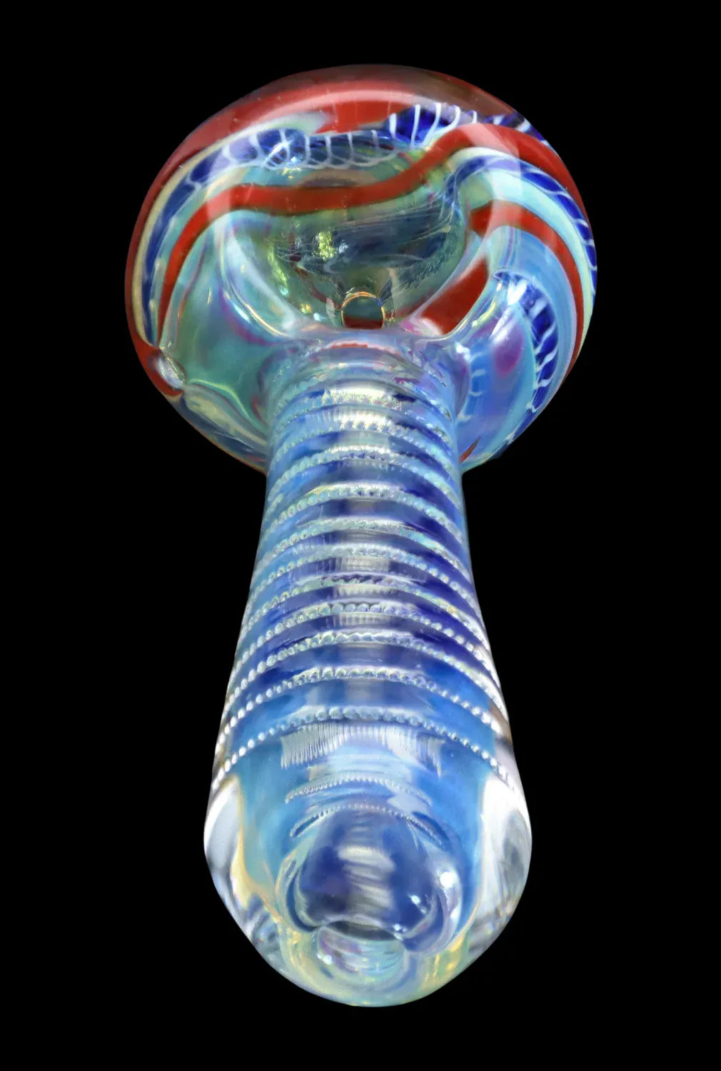 Low-angle close-up of the DHC Engraved Fumed Spoon Pipe - 3 in. showing its ribbed glass stem and red-and-blue swirled bowl against a black background