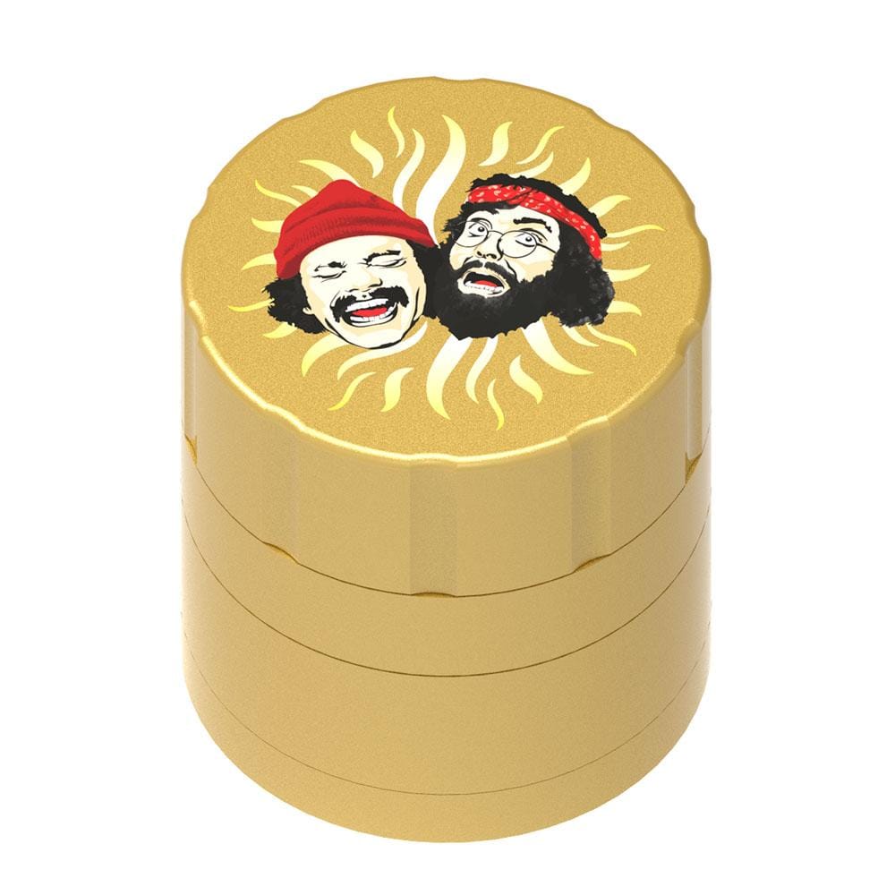 Top-down view of the gold Up In Smoke 40th Anniversary 53mm 4-Piece Grinder showing a sunburst graphic with two smiling faces on the lid.