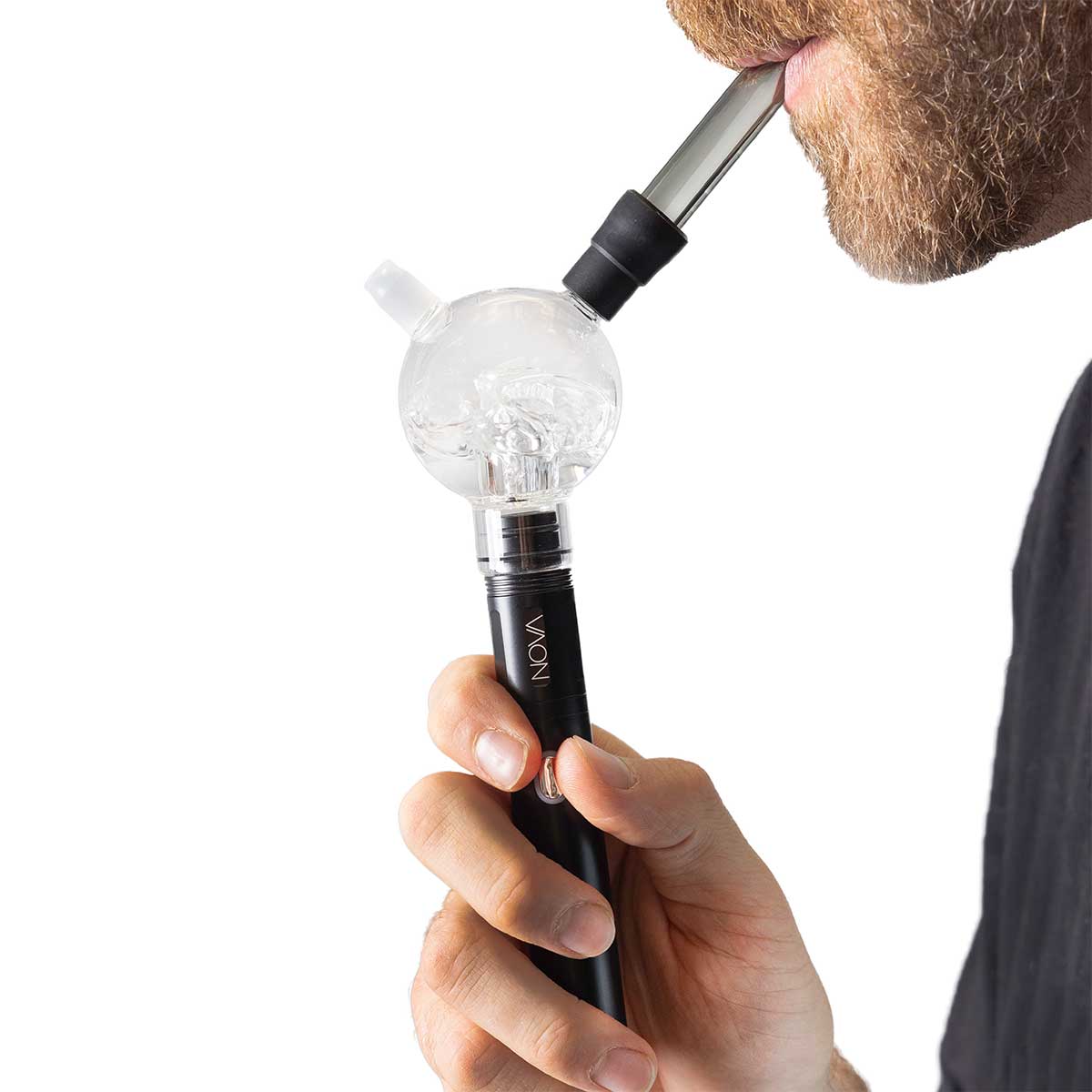 Close-up side view of a bearded person holding and inhaling from the Cipher NOVA Water Hookah Kit, showing the clear spherical glass chamber, black stem, and mouthpiece against a white background.