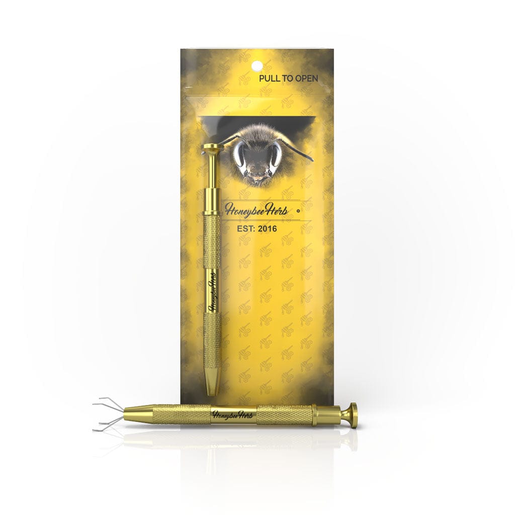 Front-facing product shot of the Honeybee Herb Dab Claw showing a gold metal claw tool resting horizontally in front of its yellow branded backing card.