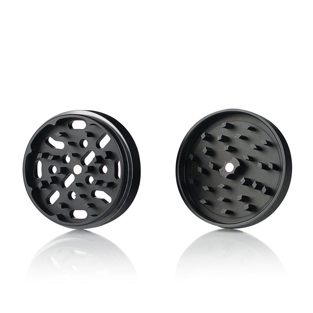 Front-facing studio shot of two separated halves of the Ryot 4Pc Jar Body Grinders in gunmetal, shown on a white reflective surface.