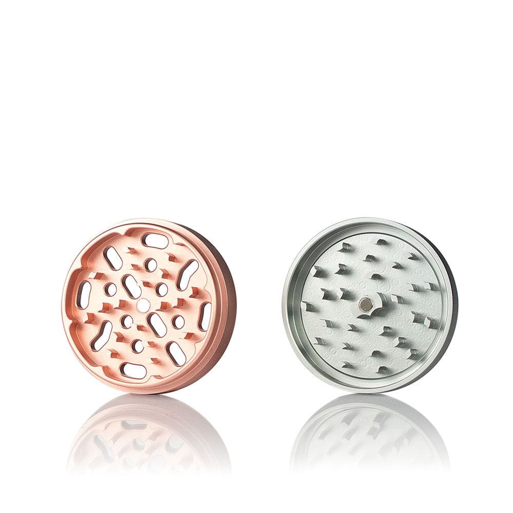 Two-piece studio shot of the Ryot 4Pc Jar Body Grinders showing a rose-gold top and silver bottom, viewed front-on with soft reflection.