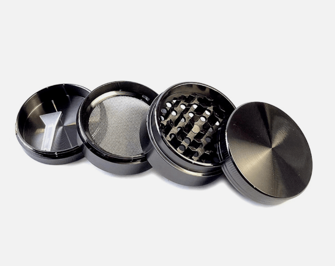 Angled close-up of a blue 4-Piece Zinc Grinder with its four screw-apart chambers laid side-by-side on a white background, showing the lid, teeth, mesh screen, and pollen catcher.