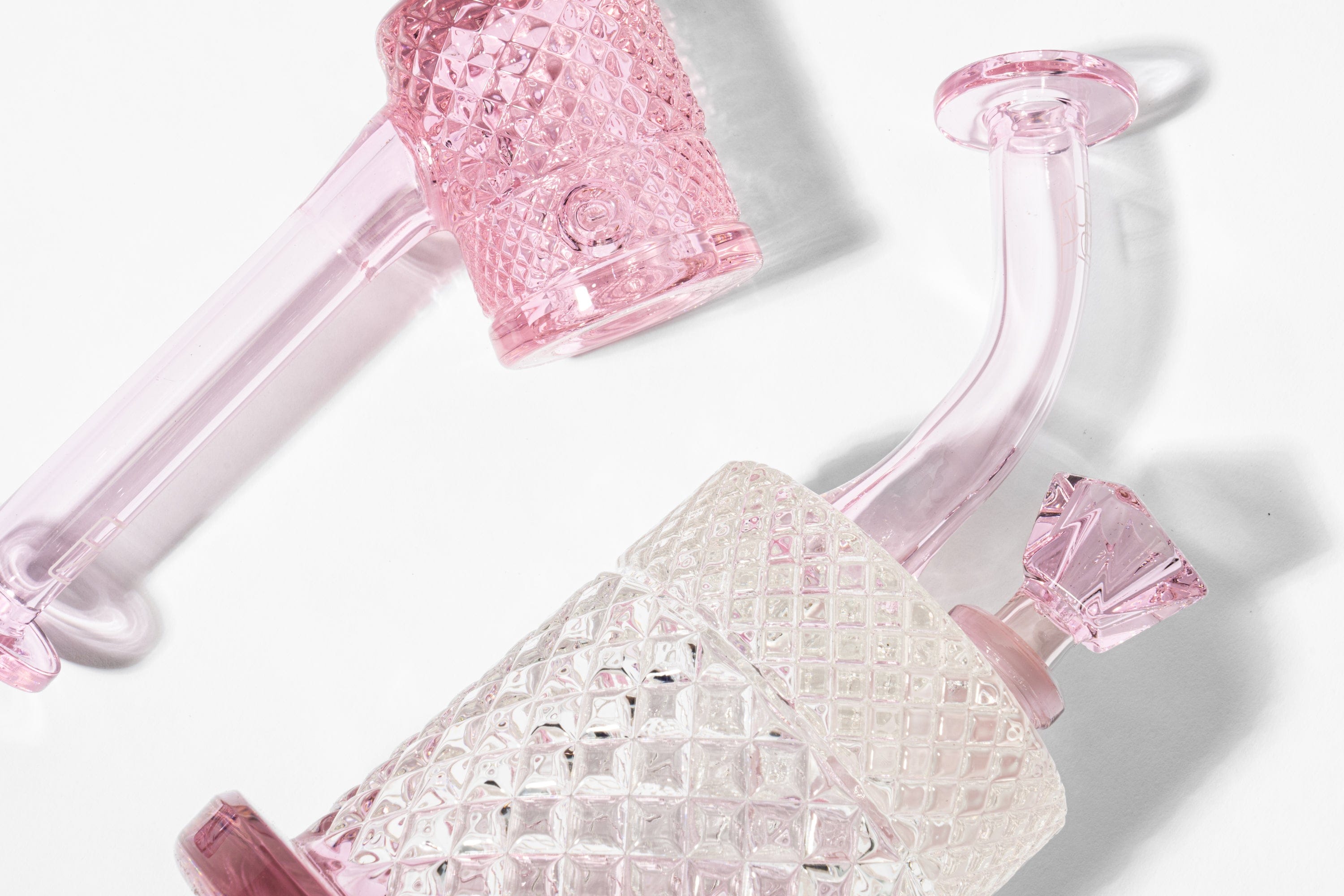 Close-up diagonal view of the Twenties Collection Bong | Pink showing the textured pink glass body, curved neck, and faceted stopper on a white background