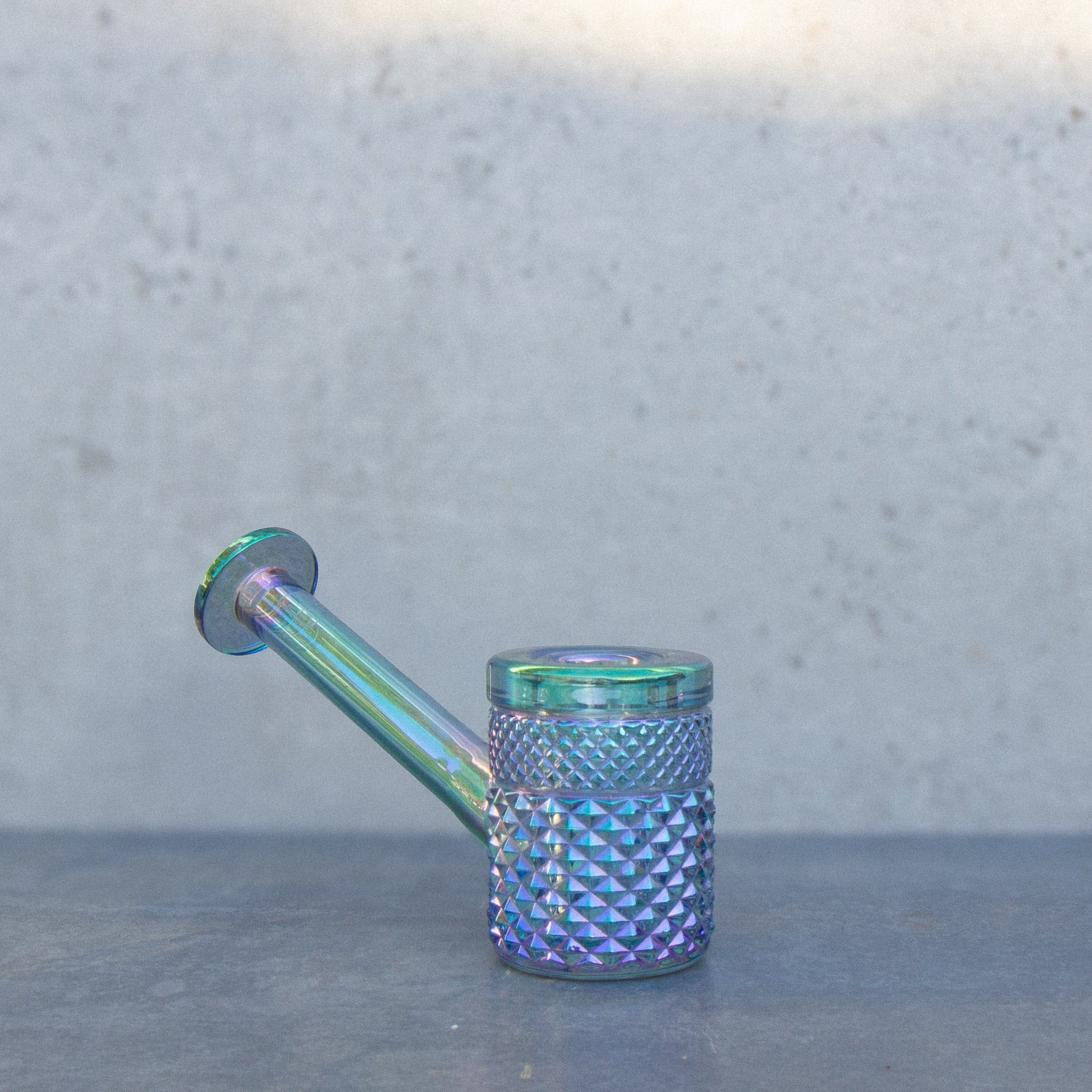 Close-up side view of the iridescent Twenties Collection Hand Pipe | Mermaid showing its textured bowl and angled stem against a soft gray background