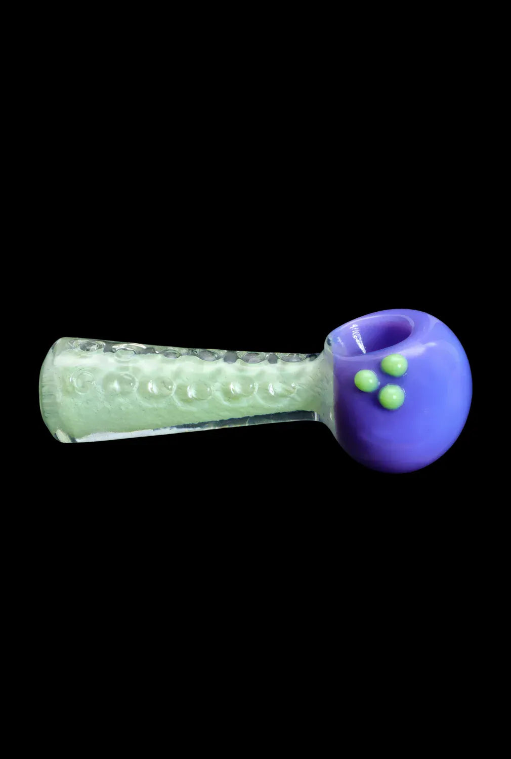 Side view of the DHC Fancy Stem Spoon Pipe - 4.5 in. showing a translucent textured green stem and a rounded glossy purple bowl with three raised green dots on a black background