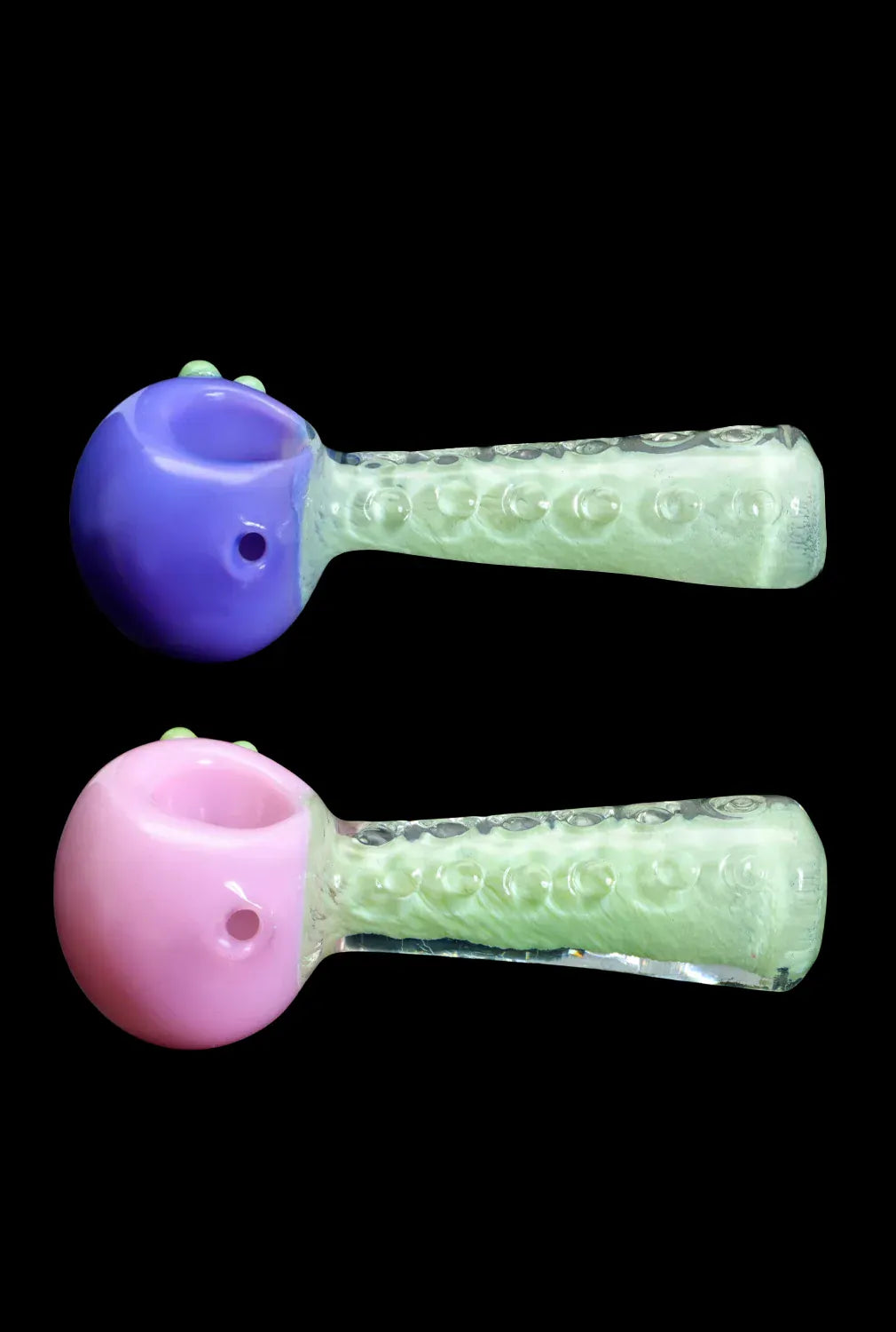 Top-down view of two 4.5 in. DHC Fancy Stem Spoon Pipe pieces, one purple and one pink bowl with textured pale green stems on a black background.