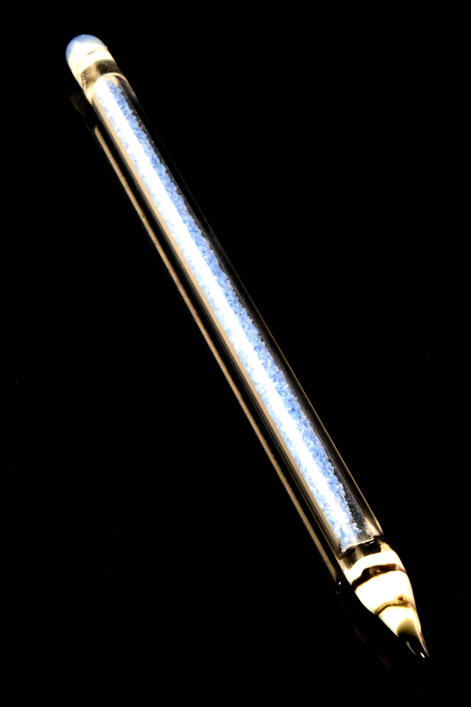 Angled close-up of the Primate Glass Pencil Dab Tool – 6″ showing its clear glass tube with blue inner texture and striped tip against a black background