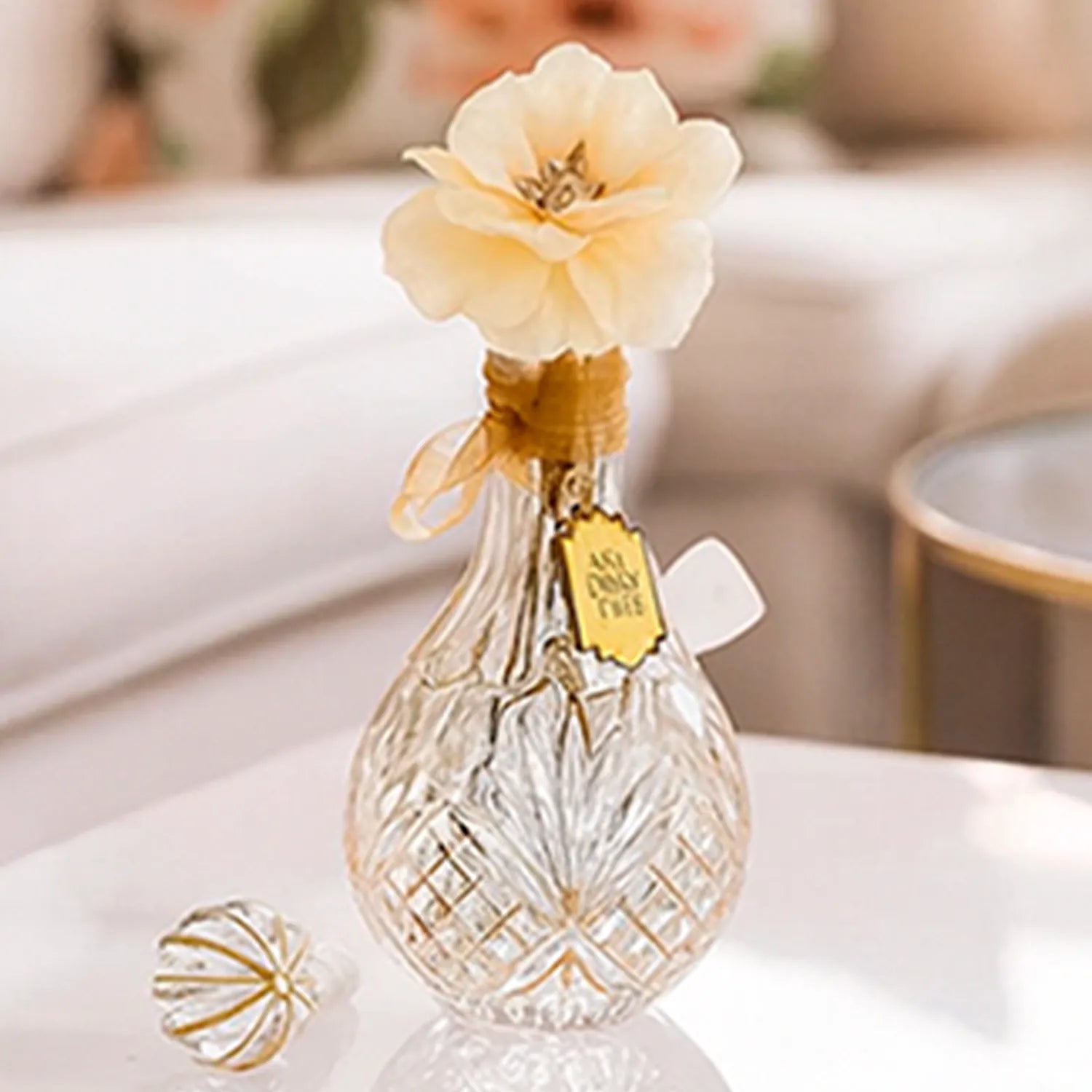 Close-up front view of the My Bud Vase "Stardust" Bong showing a textured glass teardrop body with a tied ribbon neck and a pale cream flower topper.