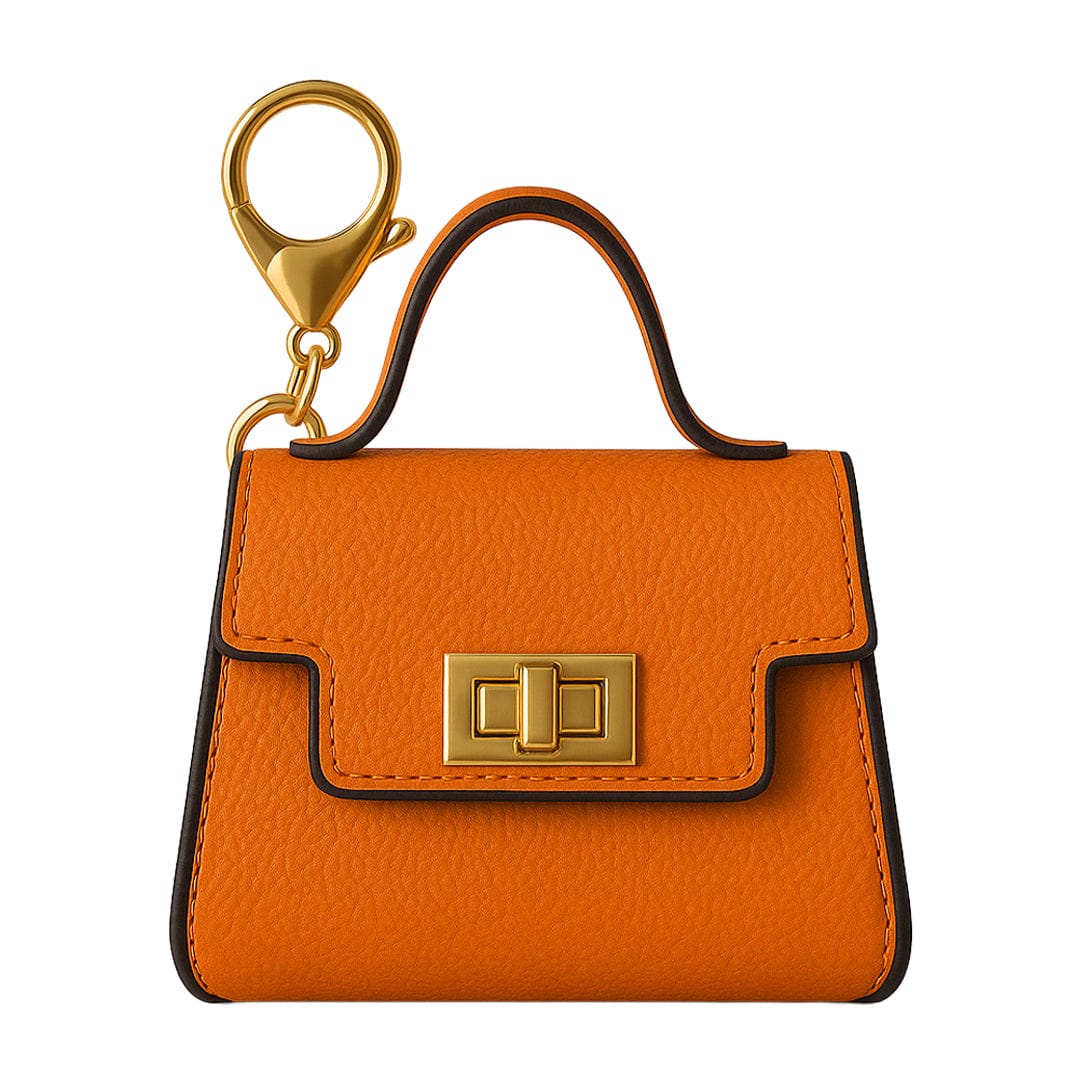 Front-facing shot of the orange Penjamin Pursejamin Vaporizer keychain bag with gold clasp and handle against a white background