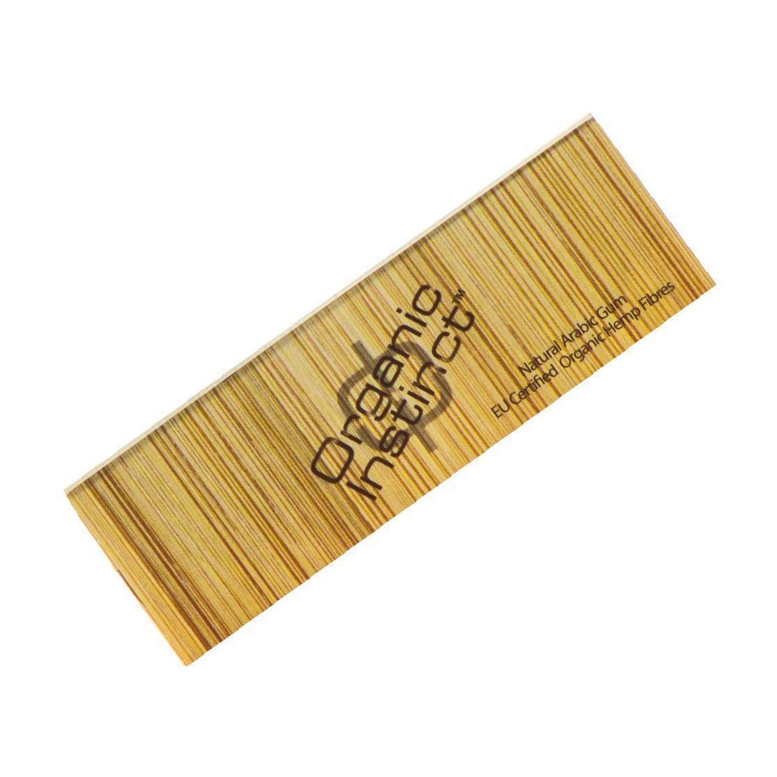 Diagonal top-down view of a wood-grain booklet labeled Organic Instinct Hemp Rolling Papers - 1 1/4" with thin vertical stripes and simple brown text on a white background