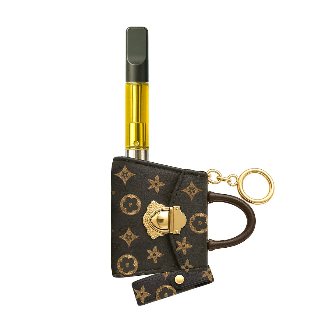 Top-down view of the Penjamin Pursejamin Vaporizer inserted into a brown monogram mini purse keychain with gold hardware.