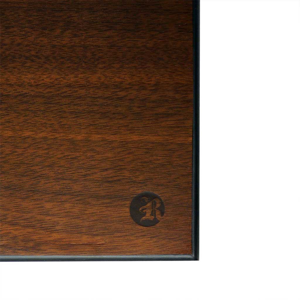 Close-up of the walnut grain and black trim on the Ryot Humidor Walnut Combo Box showing a corner with the embossed circular "R" logo.