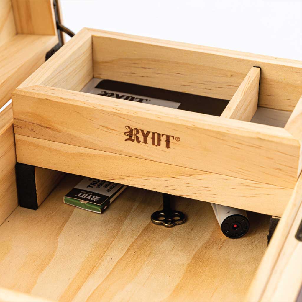 Close-up angled view inside the Ryot Humidor Walnut Combo Box showing its light walnut compartment with a removable divider, logo burn mark, and small items stored below.