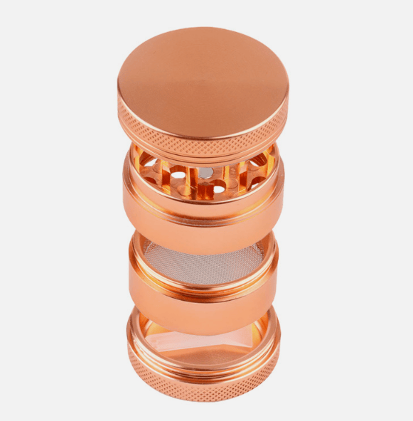 Top-down view of a copper-colored 4-Piece Zinc Grinder showing its stacked chambers, perforated grinding teeth, mesh screen, and clear collection window.