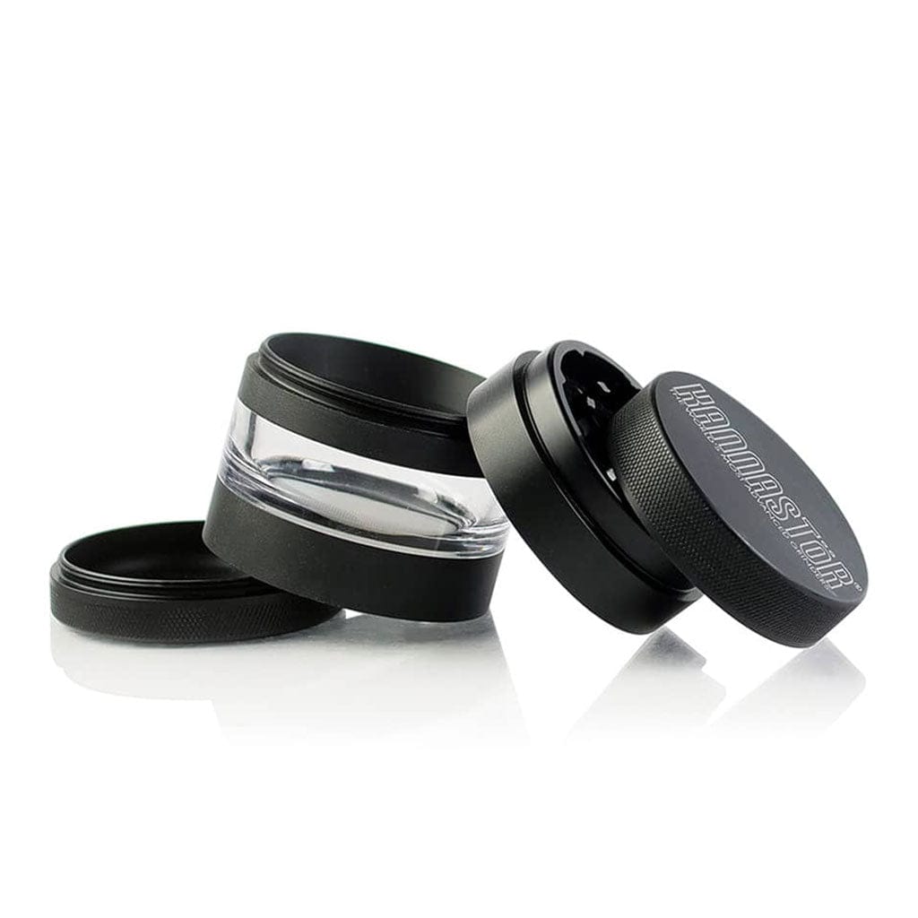 Angled close-up of three black Ryot 4Pc Jar Body Grinders with one clear midsection and a textured lid showing the logo.
