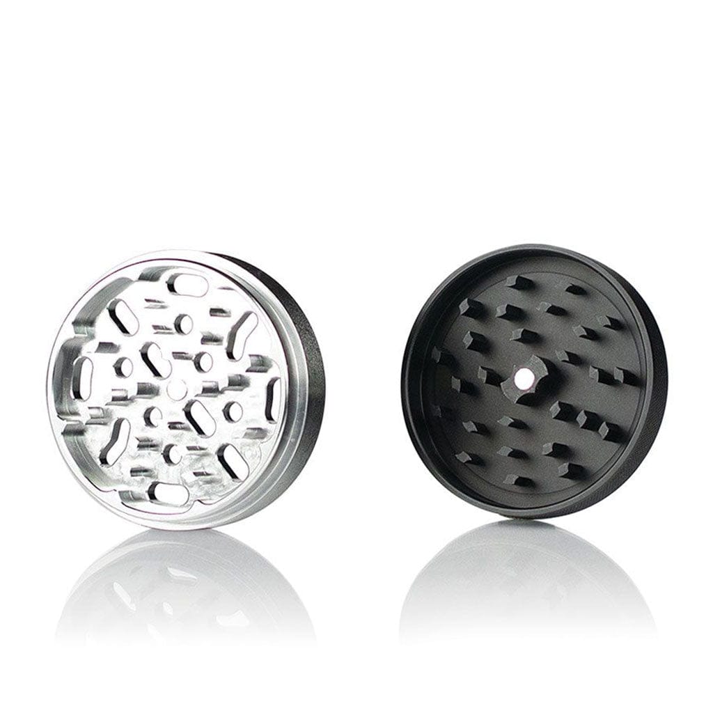 Two-piece top-down view of the Ryot 4Pc Jar Body Grinders showing a silver toothed half and a black toothed half on a reflective white surface.