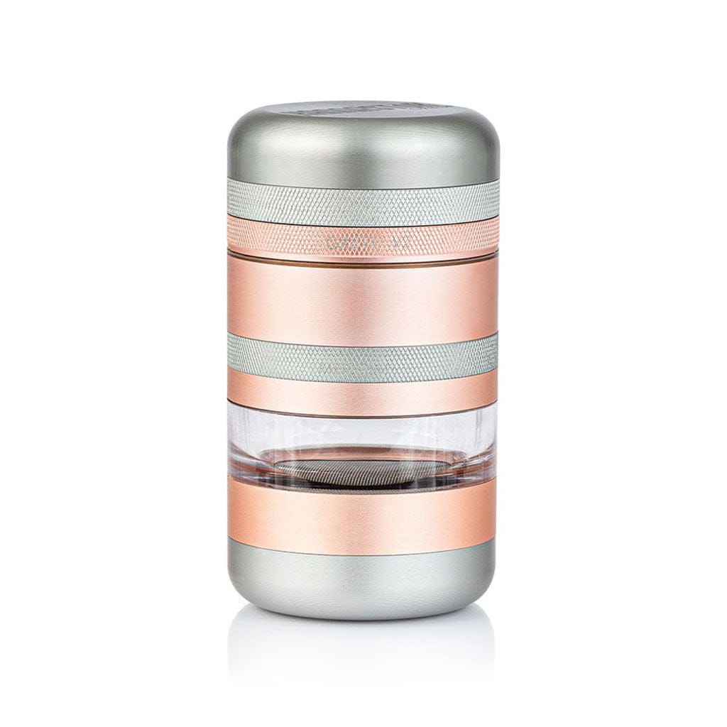 Centered studio shot of the Ryot Gr8Tr Jar Body Grinder showing its cylindrical rose-gold and silver stacked sections with a clear middle chamber.